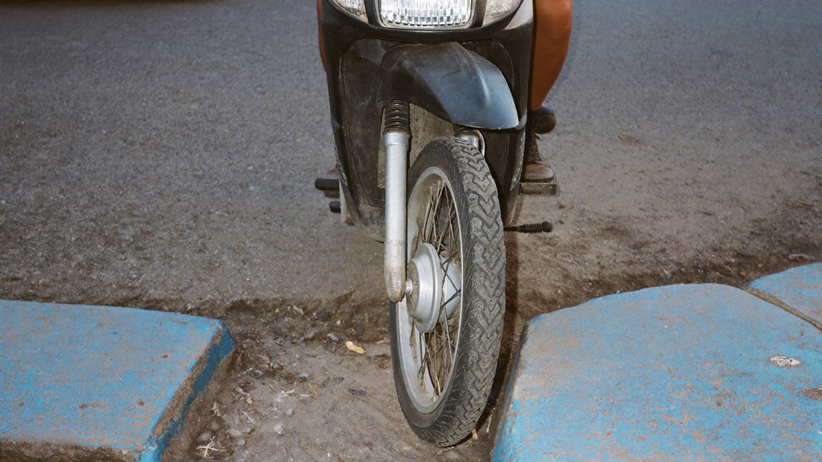 Rueda delantera de un scooter estacionado en una calle de Lima. Imagen ilustrativa generada por IA.